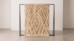 A beige shag area rug with a dark brown geometric diamond pattern, draped over a minimalist black metal stand in a clean studio setting.