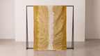 A mustard yellow and off-white ikat patterned throw blanket draped over a minimalist black metal stand in a clean, modern studio setting.